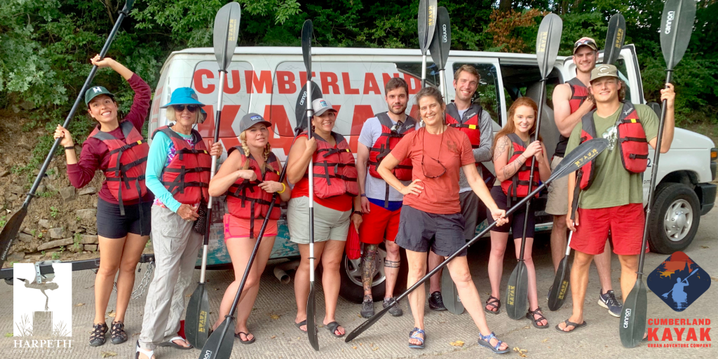 Individuals standing together with oars and in lifejackets